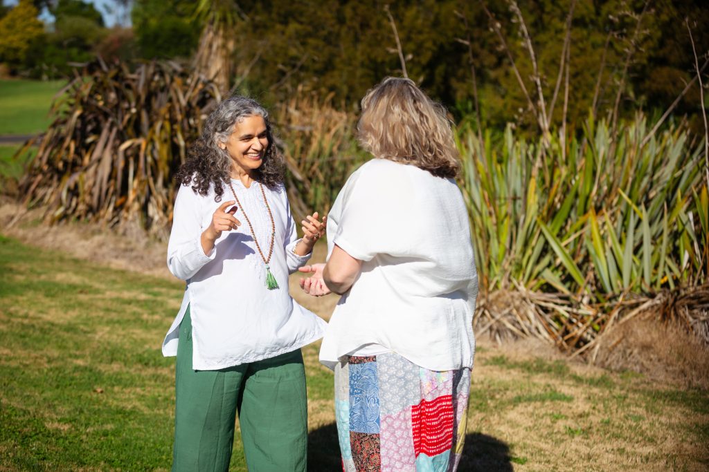 Kavita and a client walking and talking during a spiritual counselling session.